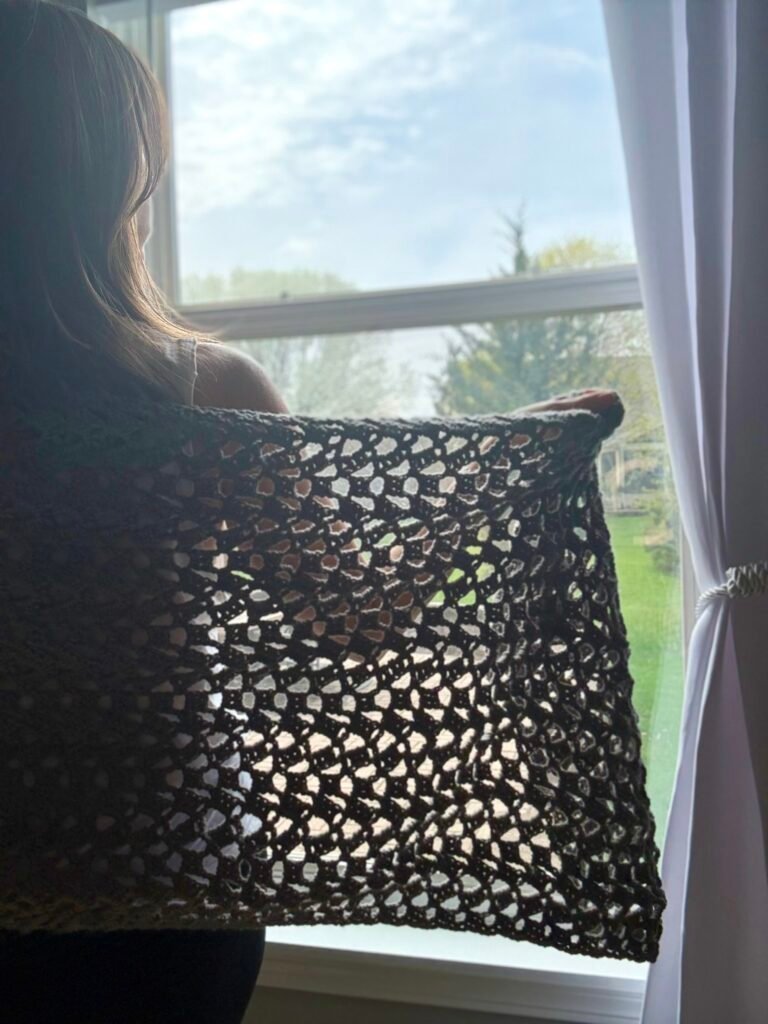 woman wearing crochet wrap in front of a window