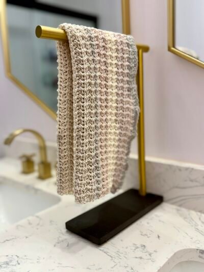 crocheted hand towel in neutral tones by a sinnk