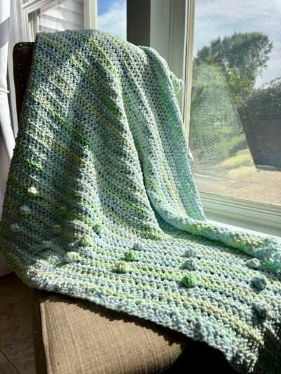 green and blue tone crochet baby blanket with bobble detailing