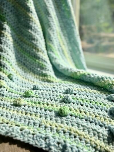 blue and green baby blanket with bobbles