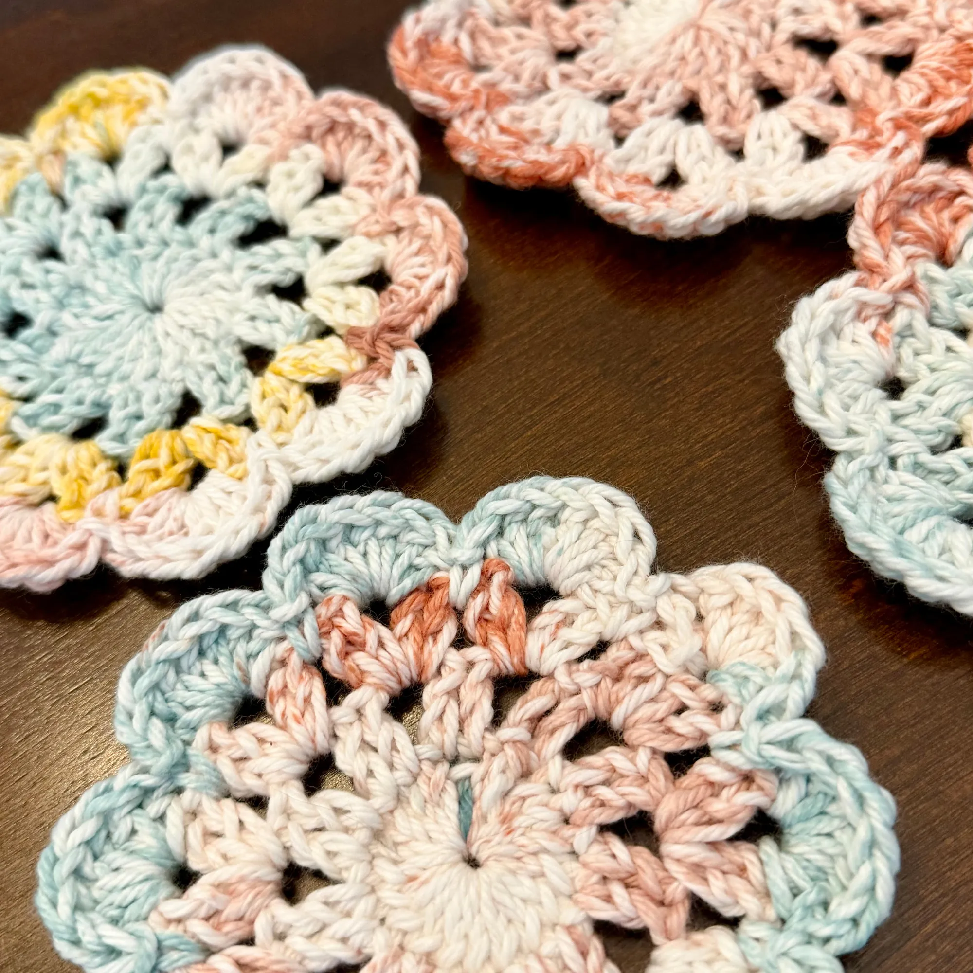 Wildflower Coasters in multiple cotton colored yarn on a table