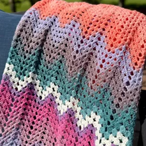 multicolored dragonfly fields chevron crochet blanket outside laying on chair