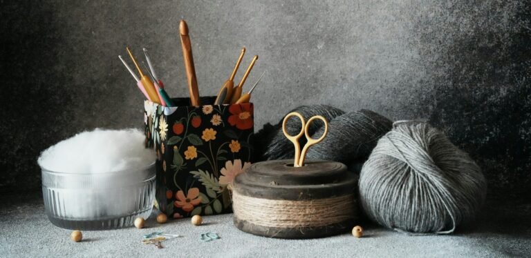 a pair of scissors, a ball of yarn, and some crochet hooks
